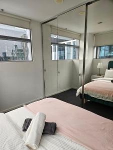 a bedroom with two beds and a mirror at Melbourne Star in Melbourne