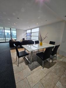 a dining room with a table and chairs and a couch at Melbourne Star in Melbourne +7 photos