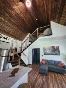 a living room with a couch and a staircase at Life's Good Retreat Bear Cottage in Brevard