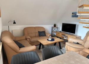 a living room with two couches and a television at Ferienwohnung Seeigel in Prerow