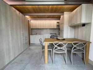 kuchnia z drewnianym stołem i krzesłami w obiekcie Loft Cùntra Maestra w Asti +6 zdjęć