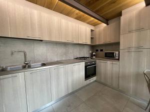 kuchnia z białymi szafkami, zlewem i kuchenką w obiekcie Loft Cùntra Maestra w Asti