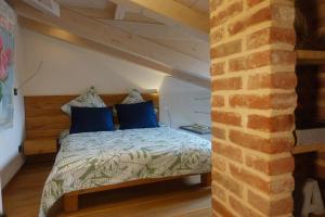 sypialnia z łóżkiem z niebieskimi poduszkami w obiekcie Loft Cùntra Maestra w Asti