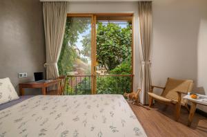 a bedroom with a bed and a window and a desk at Forest Tag Homestay in Hue