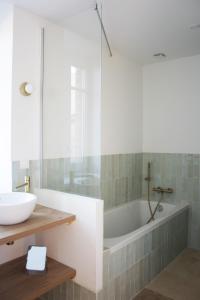 a bathroom with a tub and a sink at Le Carrouge, jolie maison cancalaise in Cancale