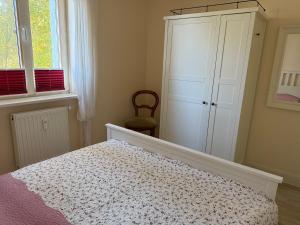 a bedroom with a bed and a cabinet and windows at Ferienwohnung Möövnest in Prerow