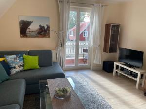 a living room with a couch and a tv at Ferienwohnung Möövnest in Prerow