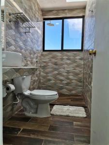 a bathroom with a toilet and a window at Bonita habitación con pequeña piscina a aire libre in Puerto Morelos +15 photos