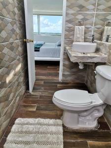 a bathroom with a toilet and a sink and a mirror at Bonita habitación con pequeña piscina a aire libre in Puerto Morelos