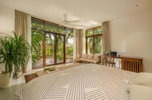 a large bedroom with a large bed and large windows at Forest Tag Homestay in Hue +46 photos