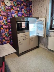 a kitchen with an oven and an open refrigerator at Apartment Walnuss in Katlenburg-Lindau +16 photos