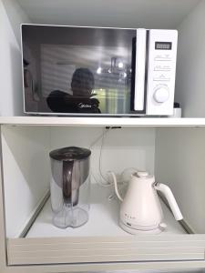 a microwave sitting on top of a shelf with a blender at Million House in Seoul