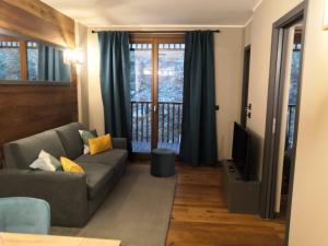 ein Wohnzimmer mit Sofa und Fernseher in der Unterkunft Himalaya - Apartments in Prato Nevoso