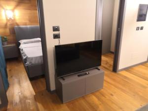 einen Flachbild-TV auf einem Stand in einem Zimmer in der Unterkunft Himalaya - Apartments in Prato Nevoso