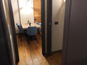 ein Esszimmer mit einem Tisch und blauen Stühlen in der Unterkunft Himalaya - Apartments in Prato Nevoso
