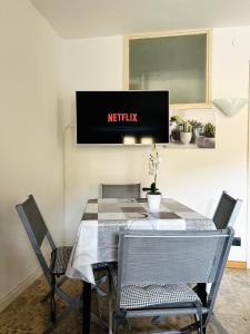 a dining room table with chairs and a television on the wall at La casa del Cervino in Breuil-Cervinia
