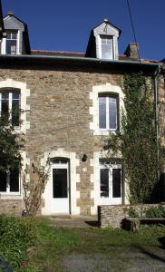 an old brick house with white doors and windows at Le Carrouge, jolie maison cancalaise in Cancale