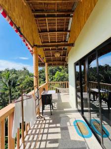 uma varanda de uma casa com uma mesa e cadeiras em Hidden Valley em Siquijor