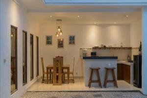 a kitchen with a counter and a table and chairs at Villa Skyler Seminyak in Seminyak