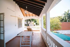 eine Veranda eines Hauses mit einem Holztisch in der Unterkunft Casa Amistad in Areguá