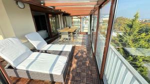 Un balcón con dos sillas y una mesa. en Luxury Penthouse on Rosehill with free garage -240sqm, en Budapest