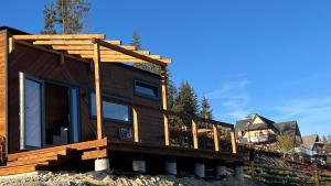 a wooden house with a deck on top at Flow Hill in Kościelisko +29 photos