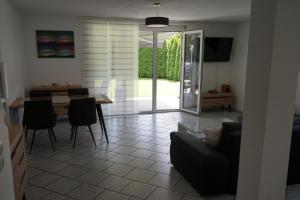 a living room with a couch and a table with chairs at Ferienwohnung mit gemütlicher Terrasse im Nordschwarzwald in Oberreichenbach