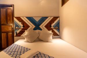 um quarto com uma cama com cabeceira de madeira e travesseiros em Private Beachfront El Nido - Sa Dulo Villa Diapila Bay em El Nido mais 26 fotografias