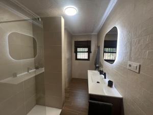 un bagno con un lavandino, una vasca e uno specchio di Casa del Cura a Calasparra