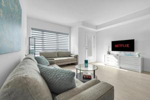 a living room with a couch and a tv at Posh 4 Bed Home with Backyard in Great Location in Burlington