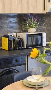 a microwave on a kitchen counter with a table with a vase of a flower at Inspiracion Valencia in Valencia +9 photos