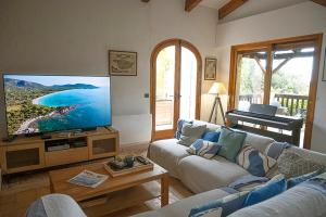 a living room with a large flat screen tv at Grande Villa, Corse du Sud, Domaine privé de Cala Rossa in Porto-Vecchio