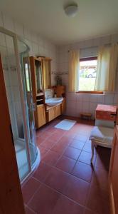 a bathroom with a shower and a tiled floor at Ferienhaus Vier Jahreszeiten in Reichenau