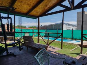 a deck with a bench and a swimming pool at Don Gregorio in Empalme Lobos