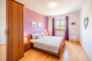 a bedroom with a bed and a window with purple curtains at Istrian Embrace, KIŽIN House - Cozy apartments in Brezovica pri Gradinu +87 photos