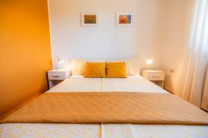 a bedroom with a large bed with yellow pillows at Istrian Embrace, KIŽIN House - Cozy apartments in Brezovica pri Gradinu