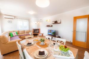 a living room with a table and a couch at Istrian Embrace, KIŽIN House - Cozy apartments in Brezovica pri Gradinu