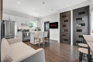 a kitchen with a couch and a table in a room at Luxury 2BR Home Near DT GO Hospitals Waterfalls in Hamilton