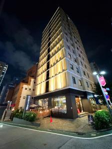 a tall building on a city street at night at HOTEL SUI AKASAKA by ABEST in Tokyo