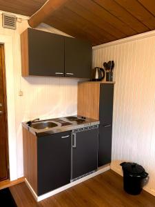 a small kitchen with a sink and a stove at Stuga 1 in Arvidsjaur +2 photos