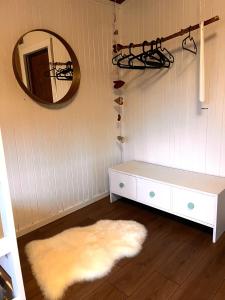 a room with a white table and a mirror and a rug at Stuga 1 in Arvidsjaur