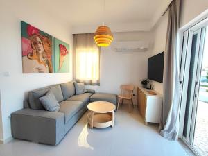 un salon avec un canapé et une table dans l'établissement Sirene beachfront central apartment near airport, à Artemi