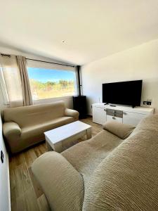 a living room with a couch and a flat screen tv at Casa Rural MaciasDehesa in Merida