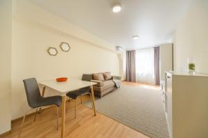 una sala de estar con una mesa y un sofá en Inn SmartHause Apartments, en Kiev