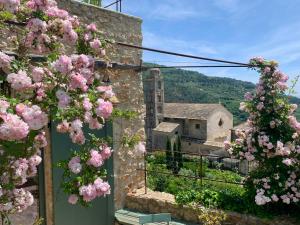 un bâtiment en pierre avec des fleurs roses devant lui dans l'établissement Càmamila sea view bedroom, à Finale Ligure