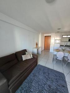 uma sala de estar com um sofá castanho e uma sala de jantar em Beach Class Boa Viagem 4010 em Recife