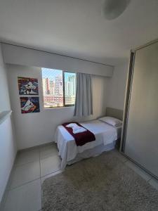 um pequeno quarto com uma cama e uma janela em Beach Class Boa Viagem 4010 em Recife