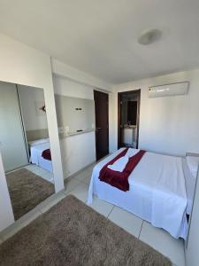 um quarto com uma grande cama branca e um espelho em Beach Class Boa Viagem 4010 em Recife mais 16 fotografias