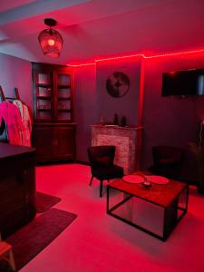 a living room with red lights on the walls at Gîte avec jacuzzi privatif in Solre-le-Château