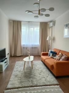 a living room with a couch and a table at ЖК Шугыла Apartment in Shugyla